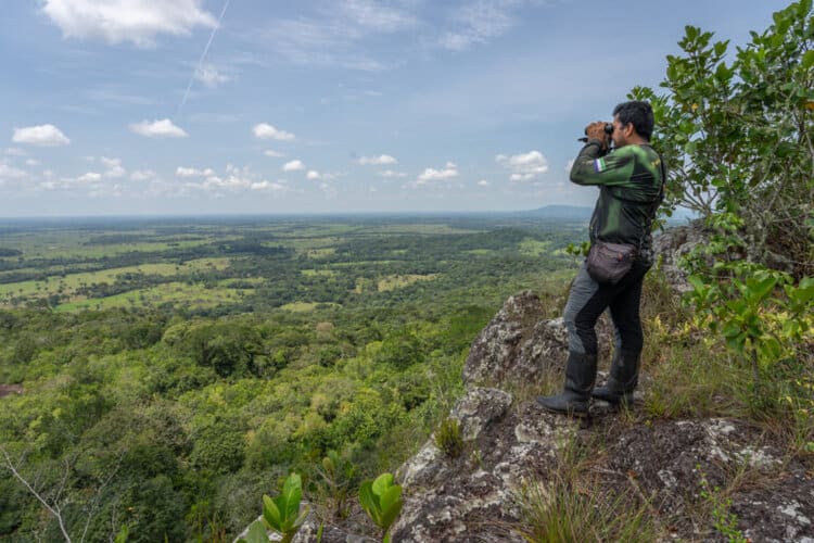 Wilmer Ramírez looks for birds of prey from the viewpoint at the top of one of the rocky formations that forms part of the Lindosa mountain range. Image by Sebastián Di Doménico.