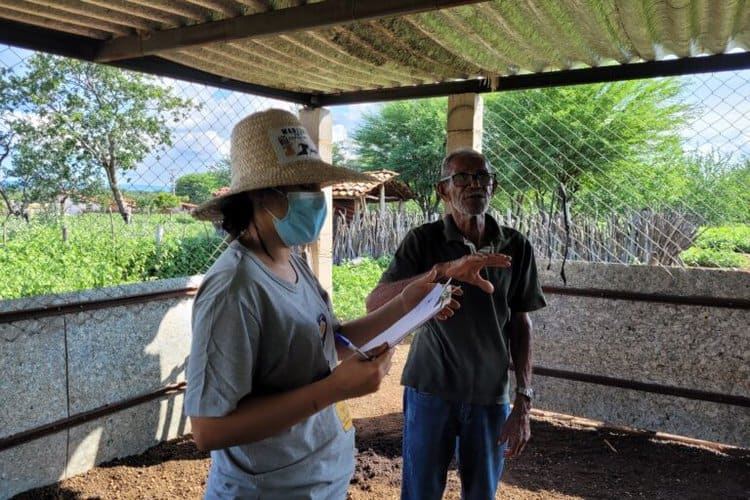 An Amigos da Onça researcher, left, and a rancher inspect a livestock pen designed to keep big cats out. Image courtesy of Anderson Gomes.