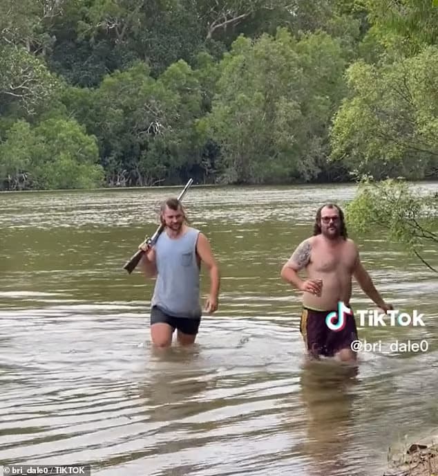Two men have been lambasted over social media after they were filmed recklessly wading through crocodile-infested waters in Far North Queensland